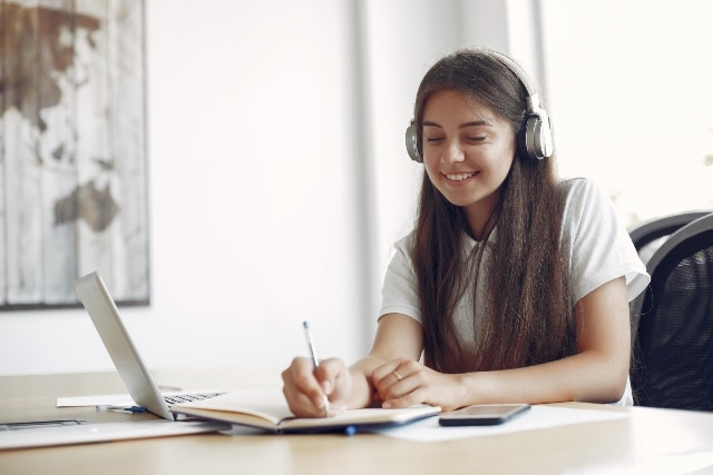 young student sitting at the table and use the laptop 1